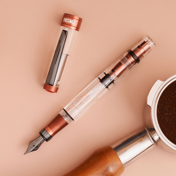将图片加载到图库查看器,A TWSBI Diamond 580 AL R Affogato with Onyx fountain pen featuring a transparent barrel, copper-colored aluminum accents, and a black steel nib with matching trim, displayed in a clear presentation case.