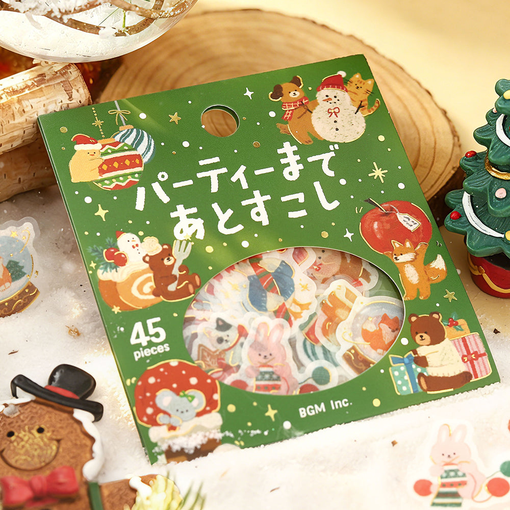 BGM Just a Little Longer Until the Party flake seal pack on a wooden slice with a mini Christmas tree