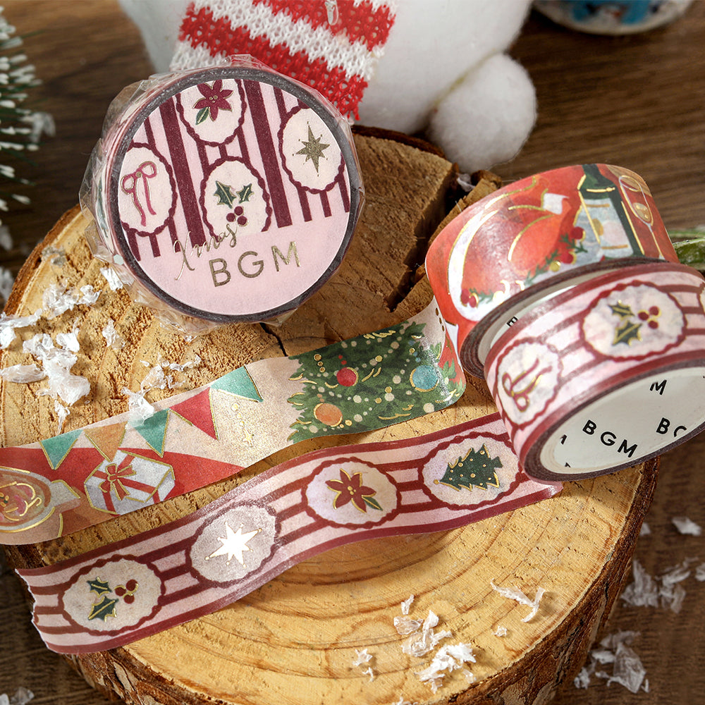 BGM Holiday Pattern washi tape roll and strip on a wooden slice beside the Gathering Around the Table tape