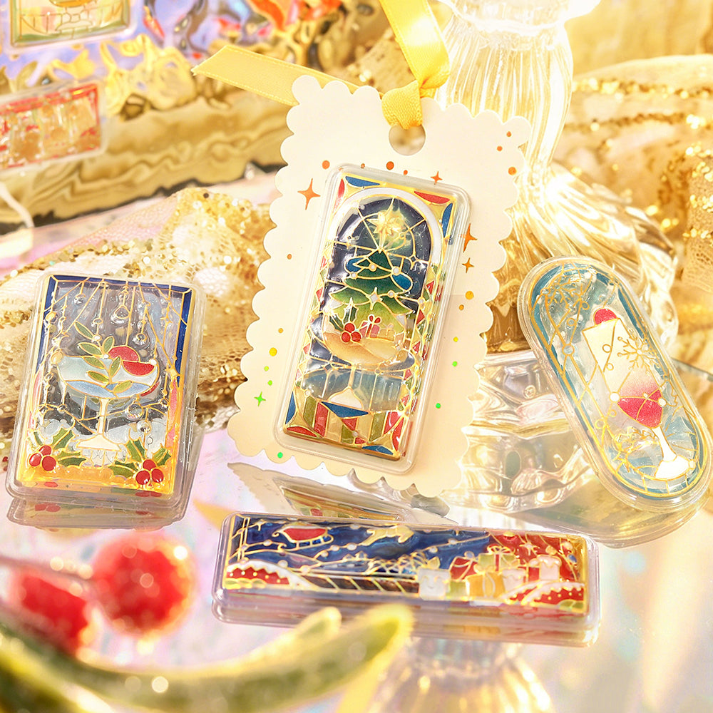Gift tag with a BGM stained-glass Christmas tree sticker, beside sleigh and dessert window stickers