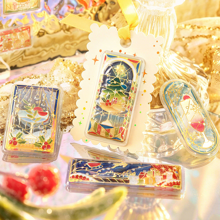 Gift tag with a BGM stained-glass Christmas tree sticker, beside sleigh and dessert window stickers