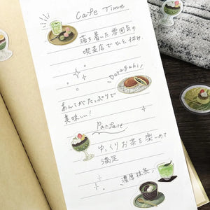Green matcha-themed café flake sticker sheet with illustrated desserts, tea bowls and small plates accented with foil.