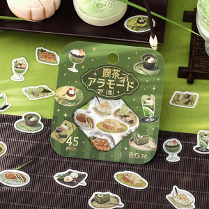Green matcha-themed café flake sticker sheet with illustrated desserts, tea bowls and small plates accented with foil.