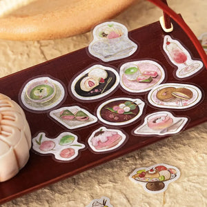 Pink-toned café flake stickers showing cakes, parfaits and delicate desserts with warm foil accents on washi paper.