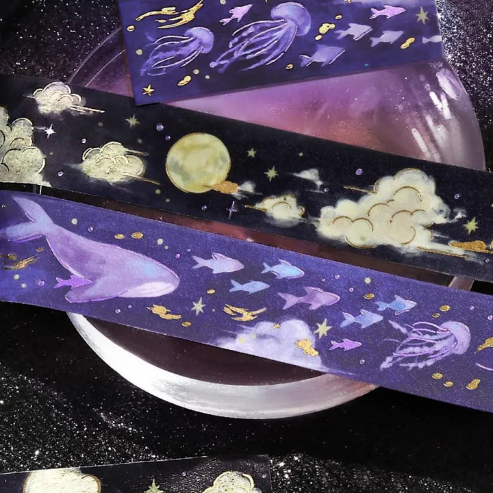 BGM Foil Stamping Masking Tape – Sky Encyclopedia: Night Calm design with whales and jellyfish in a purple starry sky, accented with gold foil moons and celestial motifs on a 20mm washi tape roll.