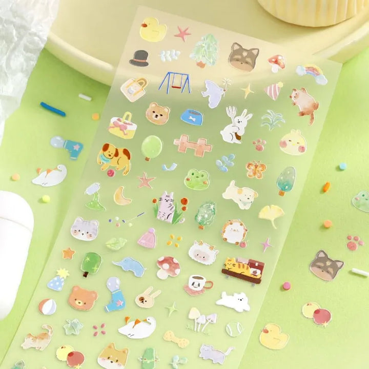 BGM Seat Seal – Animal Meets featuring one PET sticker sheet with cute animals like bears, cats, and rabbits interacting with teacups, books, and snacks. Stickers have a glossy embossed texture and playful pastel tones.