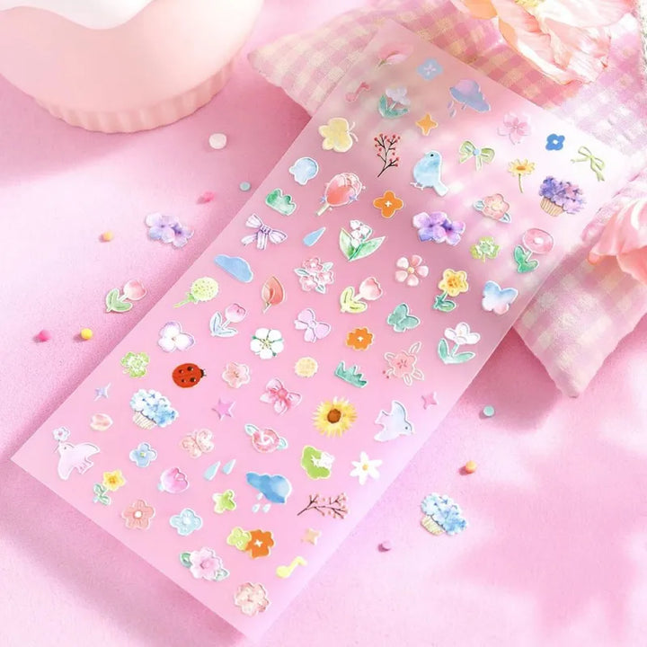 BGM Seat Seal – Bloom with one PET sticker sheet featuring delicate flowers, birds, bows, and gentle accents in pastel tones. Stickers have a glossy embossed finish.