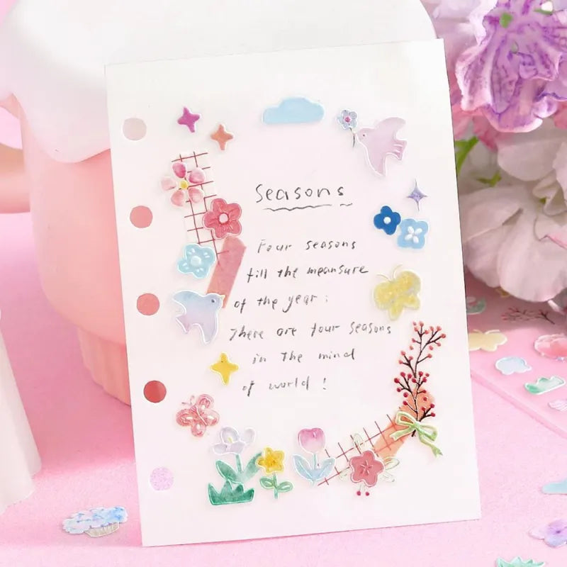 BGM Seat Seal – Bloom with one PET sticker sheet featuring delicate flowers, birds, bows, and gentle accents in pastel tones. Stickers have a glossy embossed finish.