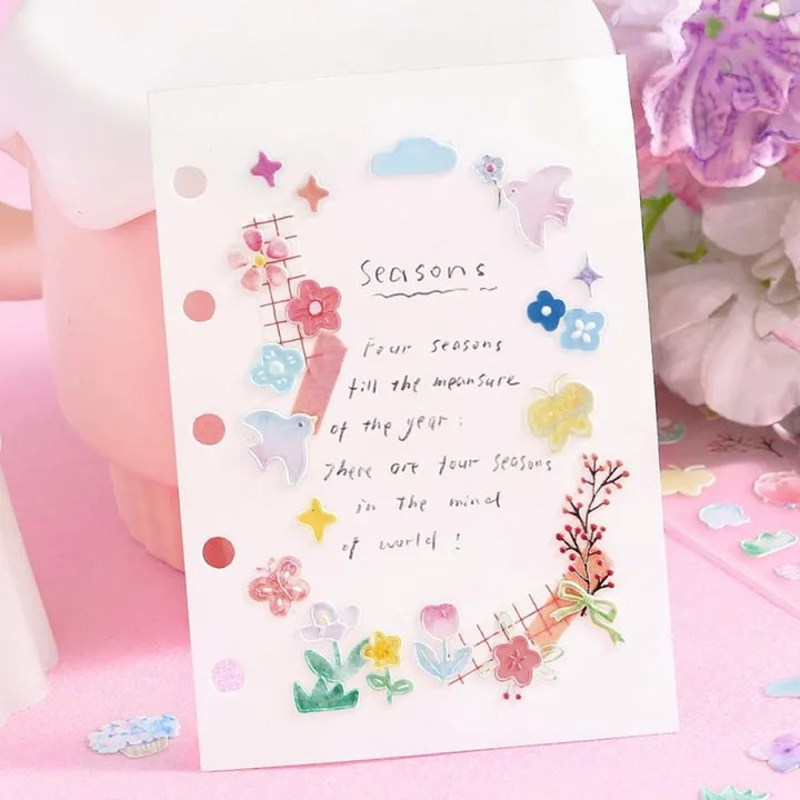 BGM Seat Seal – Bloom with one PET sticker sheet featuring delicate flowers, birds, bows, and gentle accents in pastel tones. Stickers have a glossy embossed finish.
