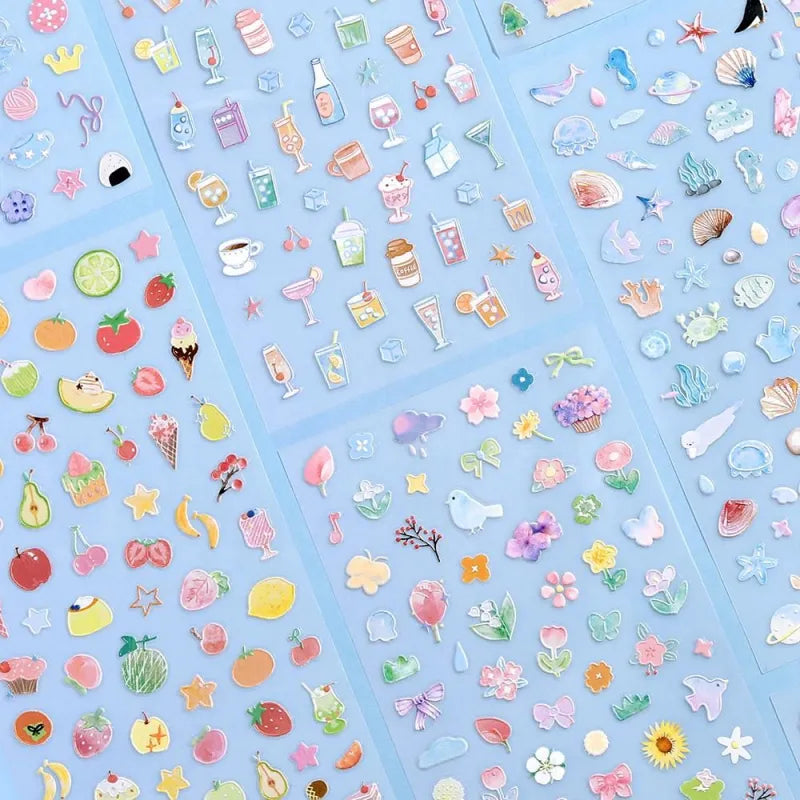 Variety of BGM Seat Seal designs, including Colorful Fruits, Soft and Fluffy Drinks, Colors of Life, Sea and Cosmos, Animal Meets, and Bloom. Each sheet features unique PET stickers with playful, textured illustrations for journaling and decorative use.
