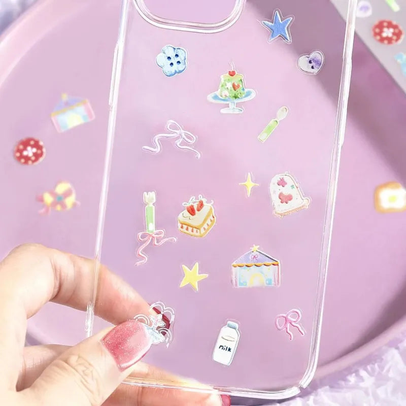 BGM Seat Seal – Colors of Life featuring a PET sticker sheet with pastel-toned icons of daily life: cameras, tea, yarn, sweets, and accessories, with a glossy embossed texture on a lavender background.