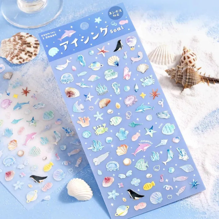 BGM Seat Seal – Ocean and Cosmos with a single PET sticker sheet featuring celestial and sea-themed icons like stars, shells, constellations, and sea creatures in pastel hues with a glossy embossed finish.