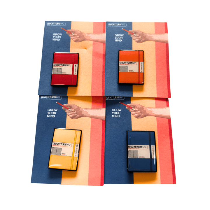 Leuchtturm1917 2026 exclusive notebook pins in Cherry, Pumpkin, Sunflower and Indigo on Grow Your Mind cards