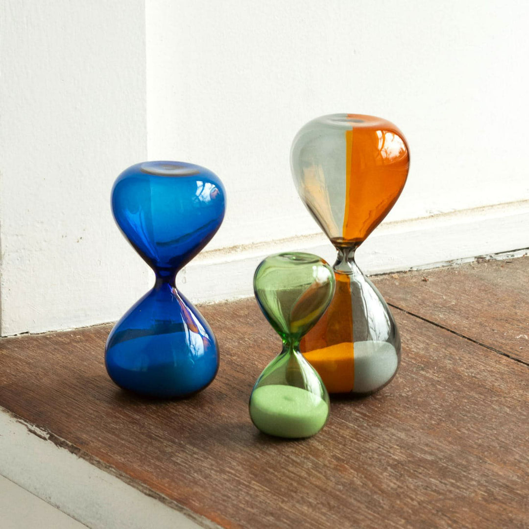 Hightide Hourglass M Blue – 5-minute glass sand timer with white sand in tranquil blue glass body.