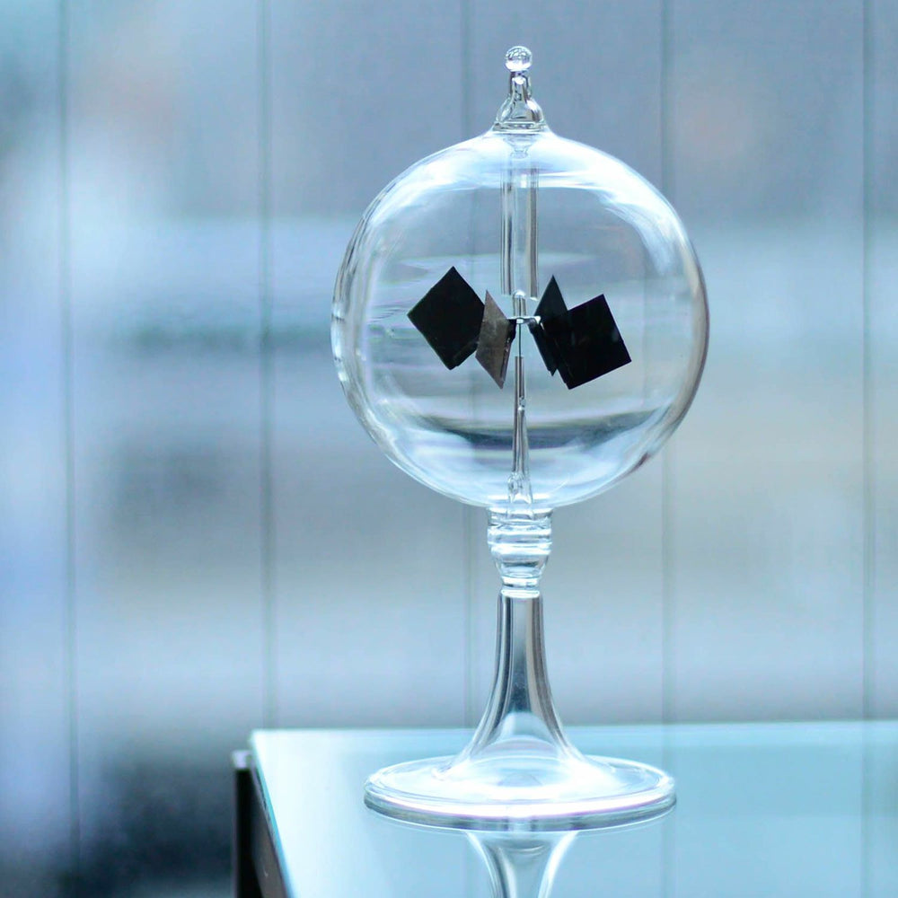Hightide Radiometer – elegant glass sphere with black spinning vanes powered by sunlight or incandescent light.