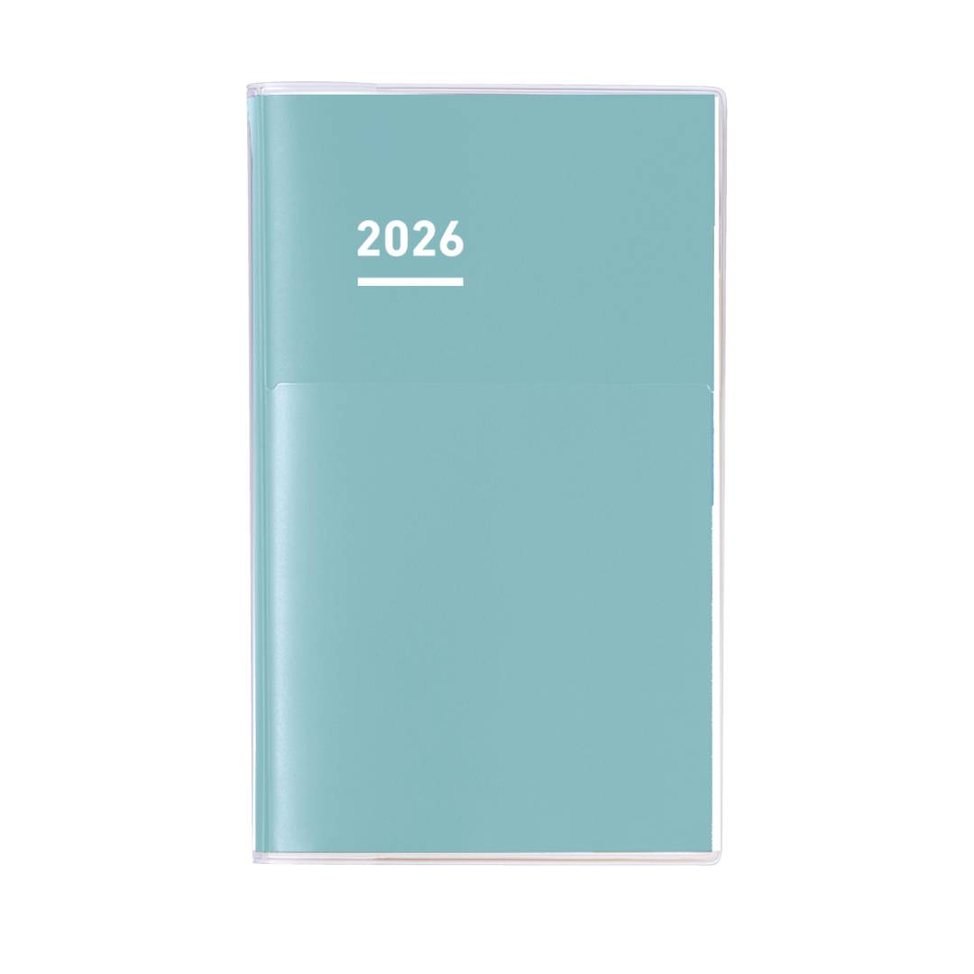 A Kokuyo Jibun Techo Diary 2026 A5 Slim Planner in refreshing matte green, designed with a sleek PVC cover and built-in pen holder. Features Kokuyo’s premium THIN paper with vertical weekly schedules, monthly blocks, yearly planning tools, and personal reflection pages.