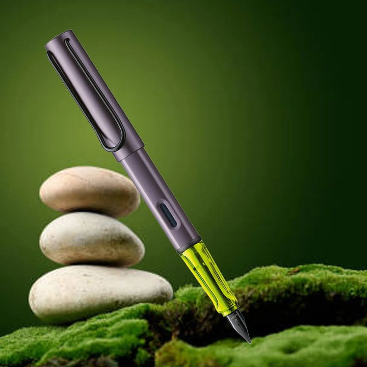 LAMY AL-star fountain pen in metallic aubergine with a translucent neon yellow grip, black steel nib, and metal clip. Includes a blue ink cartridge.