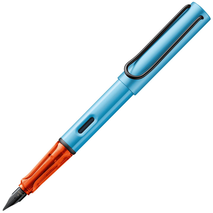 LAMY AL-star fountain pen in matte denim blue with a translucent orange grip, black steel nib, and metal clip.