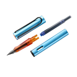 LAMY AL-star fountain pen in matte denim blue with a translucent orange grip, black steel nib, and metal clip.