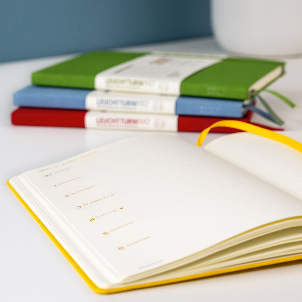 Leuchtturm1917 Colourful Seasons Edition 2027 – open planner with the four seasonal editions behind