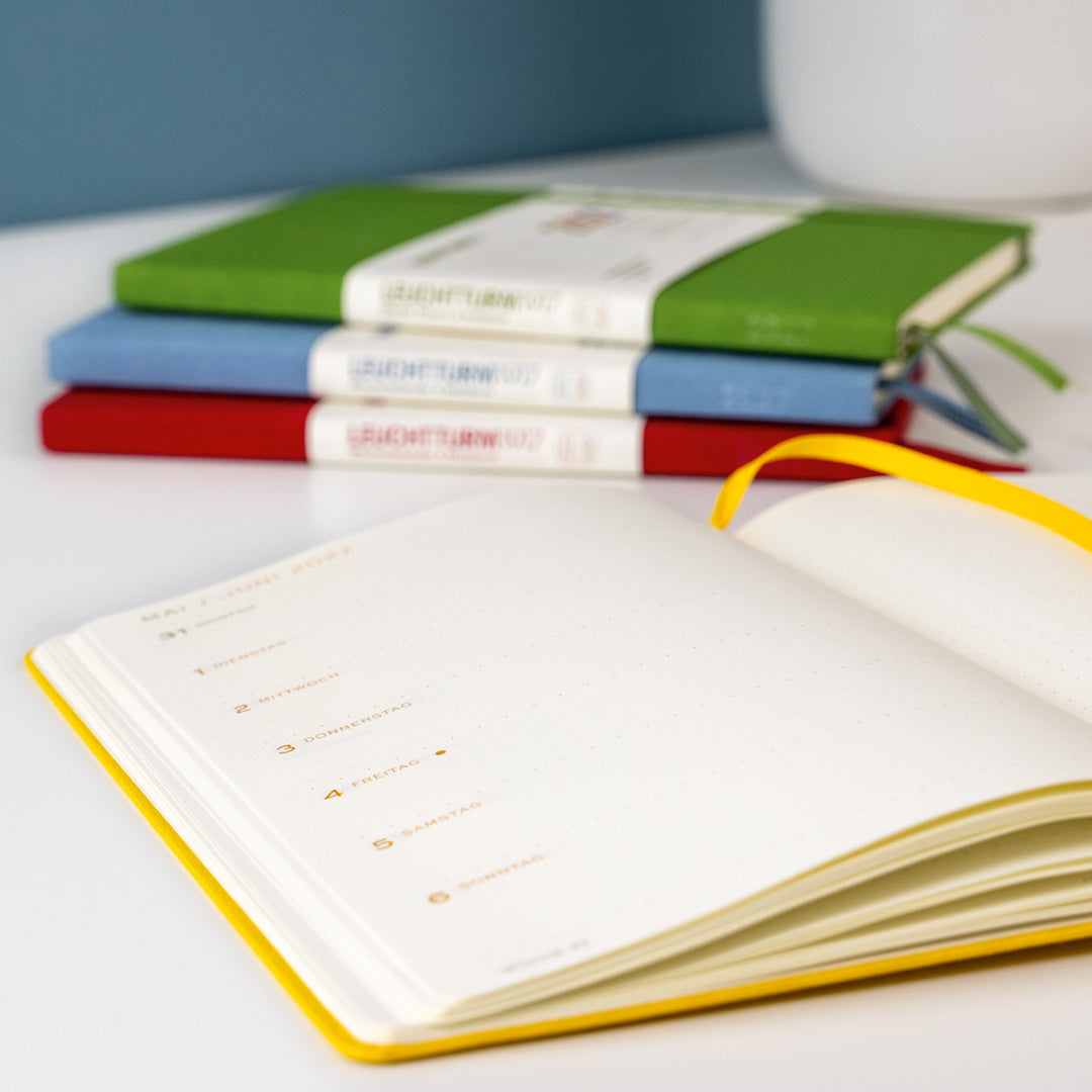 Leuchtturm1917 Colourful Seasons Edition 2027 – open planner with the four seasonal editions behind