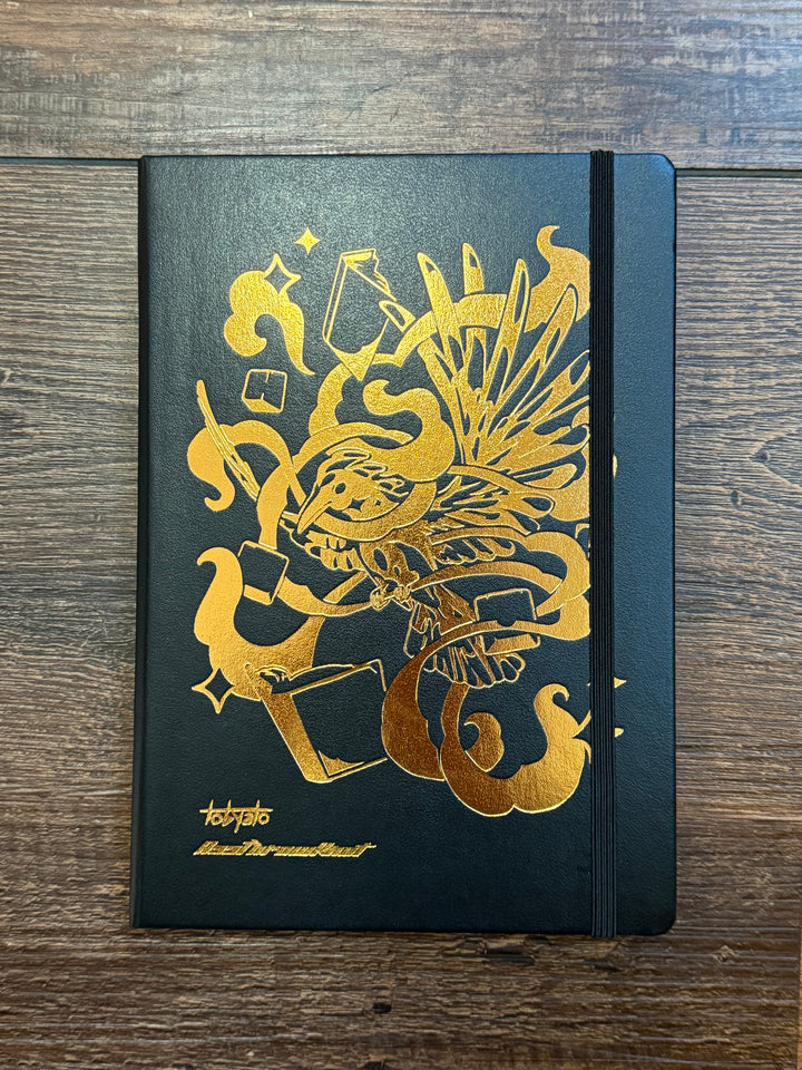 Leuchtturm1917 Tobyato Edition A5 Medium Notebook in black with ruled pages, featuring a cover design of a raven surrounded by books and typewriter keys, symbolizing creativity and knowledge.
