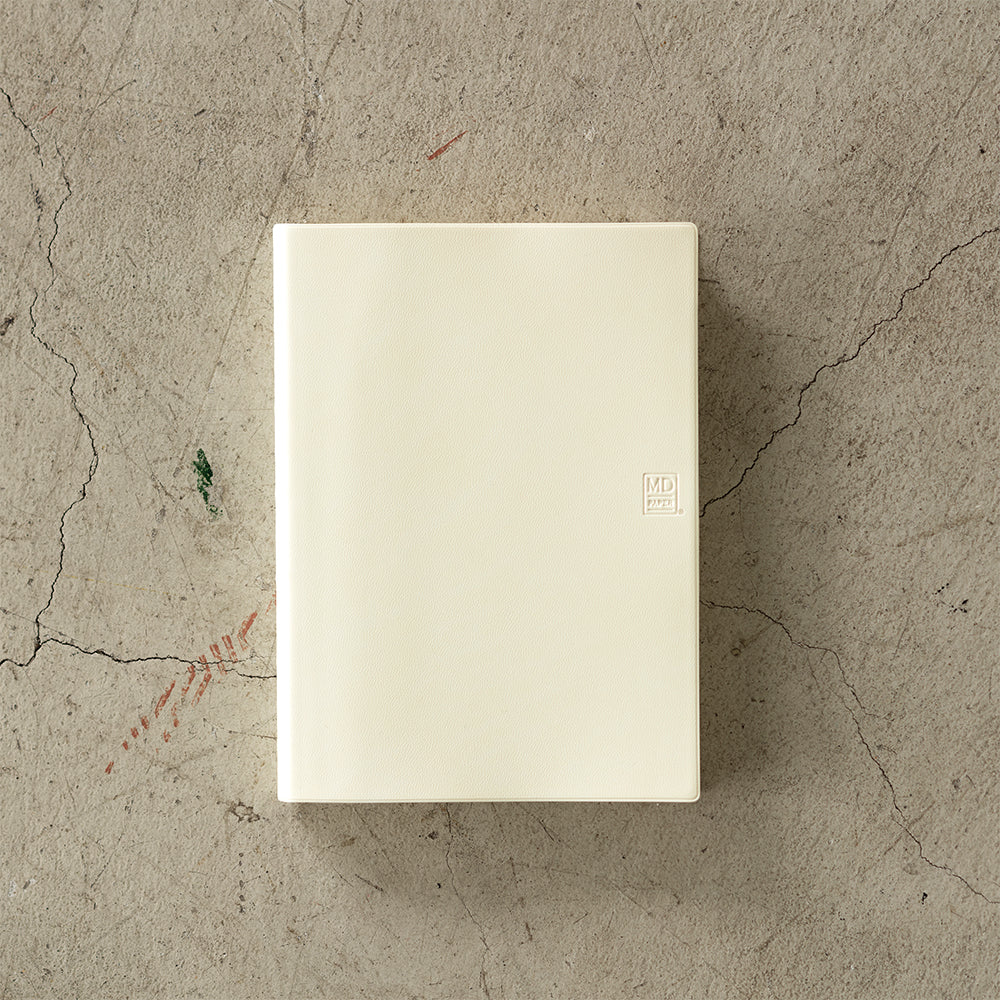 MD Notebook Diary (A5) 1 Day 1 Page 2026 with a minimalist PVC cover, year-stamped spine, and index tabs for each month. The diary is open to show a clean daily page layout on premium MD PAPER, ideal for journaling or planning.