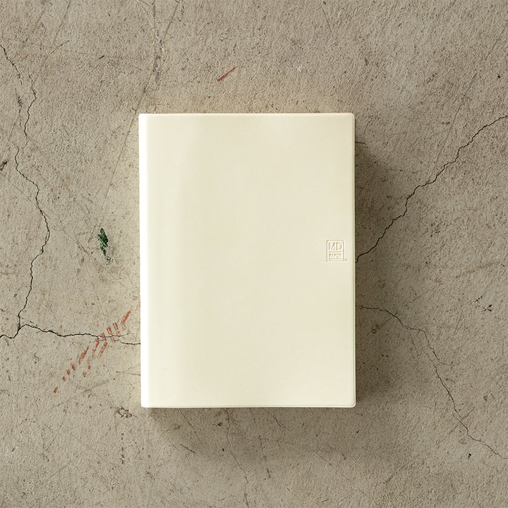 MD Notebook Diary (A5) 1 Day 1 Page 2026 with a minimalist PVC cover, year-stamped spine, and index tabs for each month. The diary is open to show a clean daily page layout on premium MD PAPER, ideal for journaling or planning.