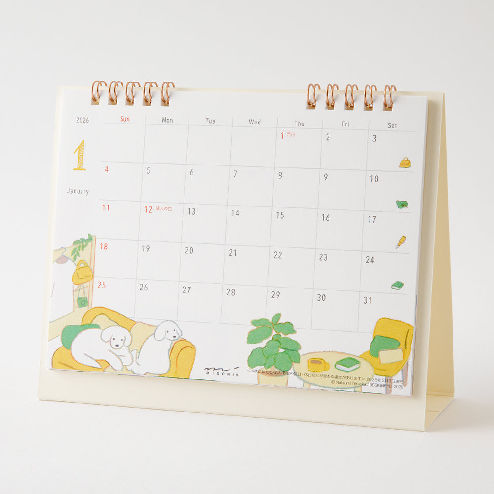 Midori Calendar Ring 2026 (M) – Dog, a compact desk calendar with colorful dog illustrations by Natsumi Teraoka, displayed upright to show its charming, hand-drawn monthly design.