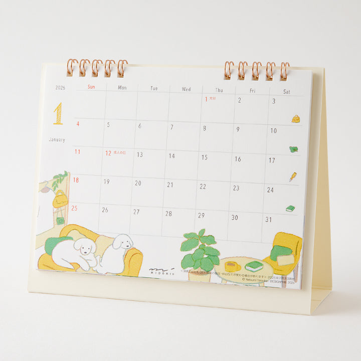Midori Calendar Ring 2026 (M) – Dog, a compact desk calendar with colorful dog illustrations by Natsumi Teraoka, displayed upright to show its charming, hand-drawn monthly design.