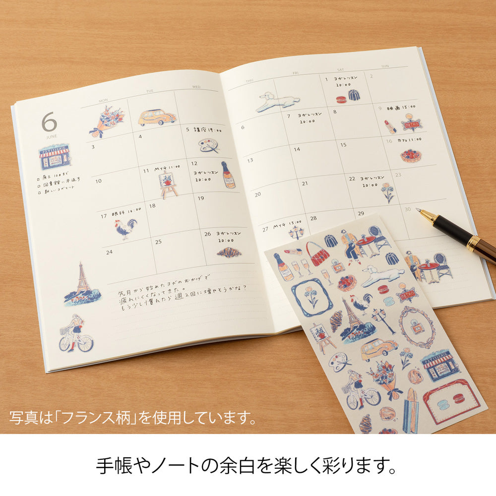 A sheet of Midori Finnish Motifs washi stickers by Yuuka Takamaru, with illustrations of reindeer, Nordic cottages, pine trees, berries, and folk embroidery patterns. The soft, pastel palette evokes the peaceful charm and traditions of Finland.