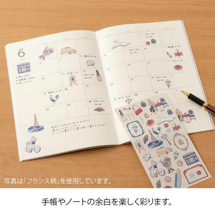 A sheet of Midori Finnish Motifs washi stickers by Yuuka Takamaru, with illustrations of reindeer, Nordic cottages, pine trees, berries, and folk embroidery patterns. The soft, pastel palette evokes the peaceful charm and traditions of Finland.