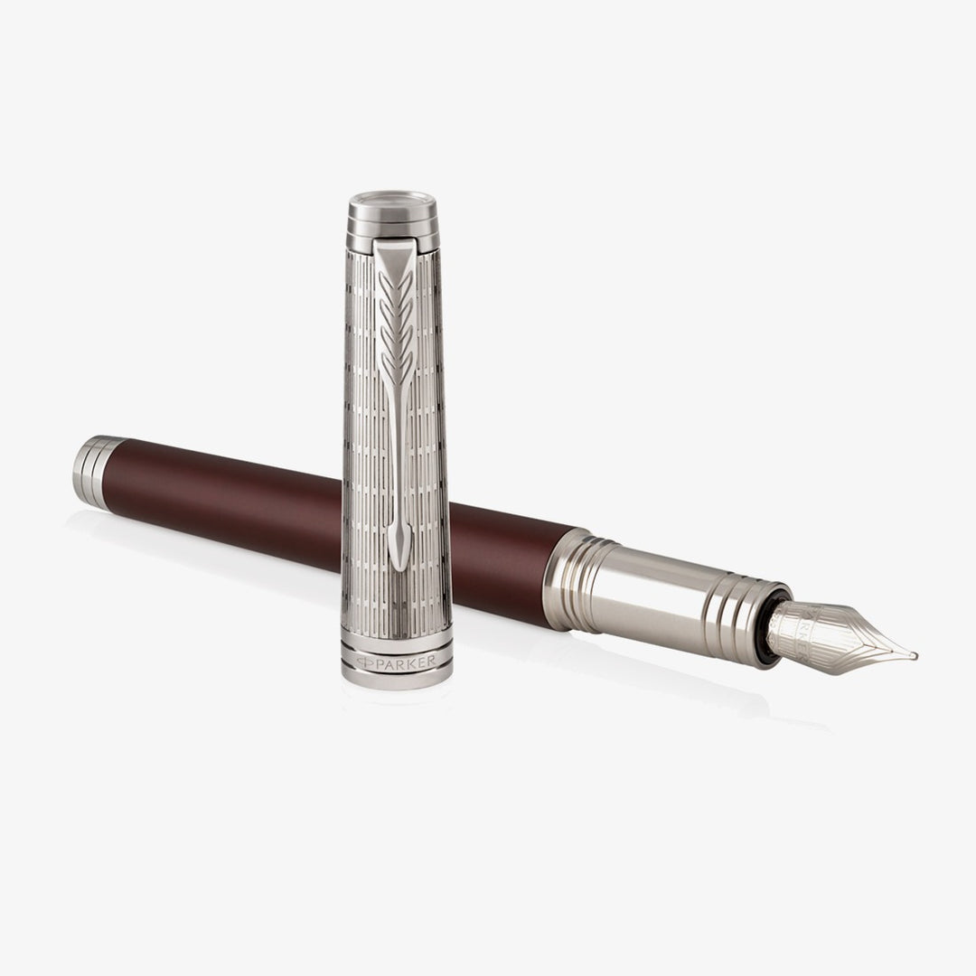 Parker Premier Custom Crimson Red fountain pen uncapped, showing the nib with the cap beside it