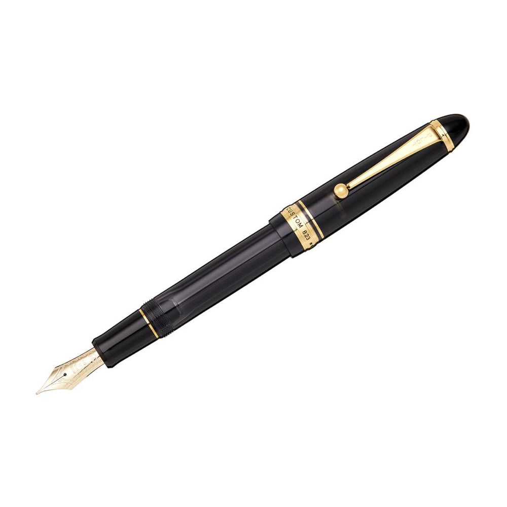 Pilot Custom 823 Fountain Pen in transparent smoky black resin with gold trim, featuring a large No. 15 14K gold nib and vacuum ink filling system – ideal for long writing sessions.