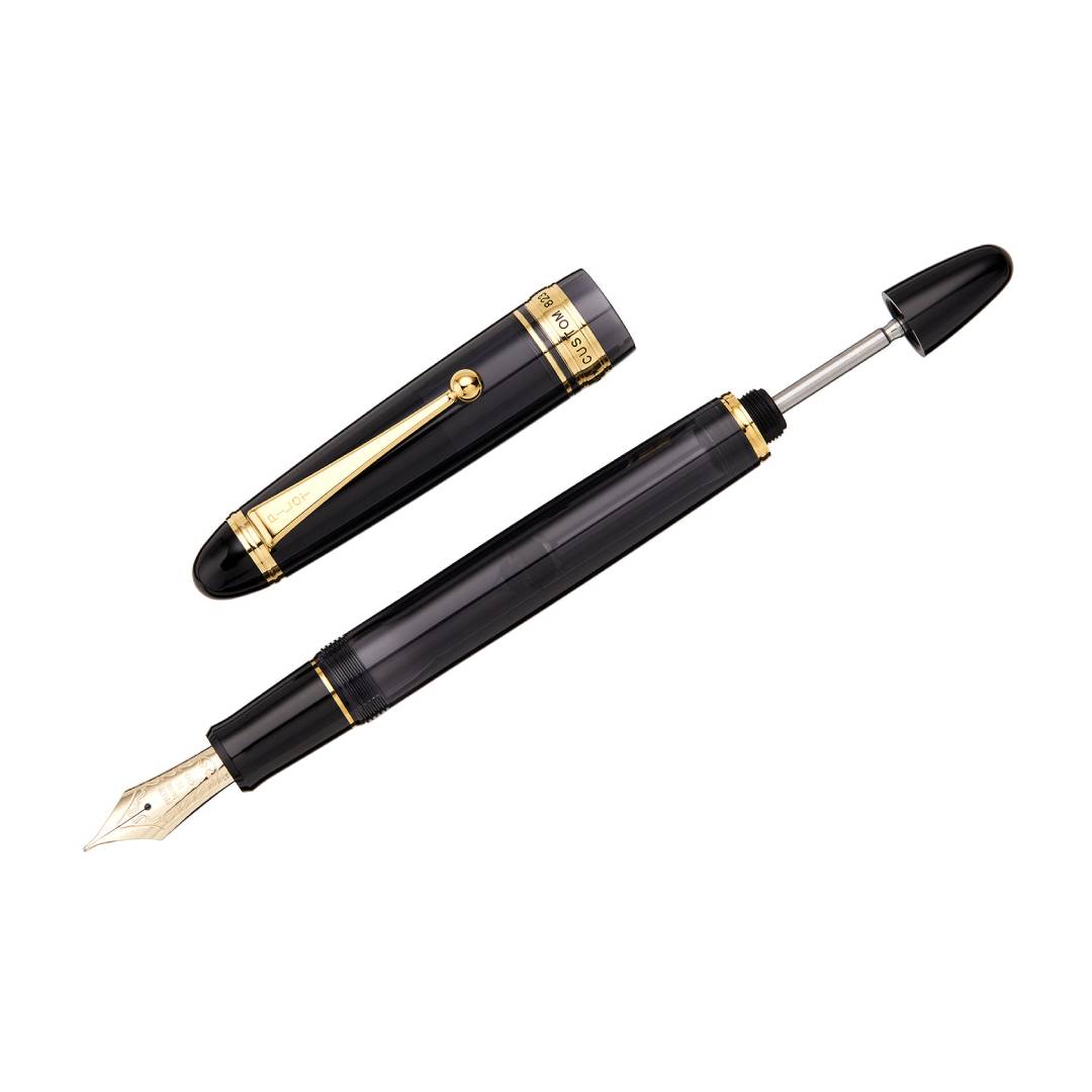 Pilot Custom 823 Fountain Pen in transparent smoky black resin with gold trim, featuring a large No. 15 14K gold nib and vacuum ink filling system – ideal for long writing sessions.