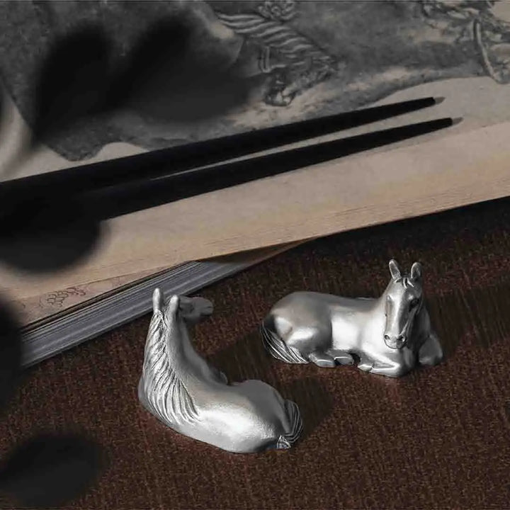 Pair of pewter horse-shaped chopstick rests, each sculpted in a calm reclining pose, symbolizing strength in stillness and adding an elegant zodiac touch to any dining table.