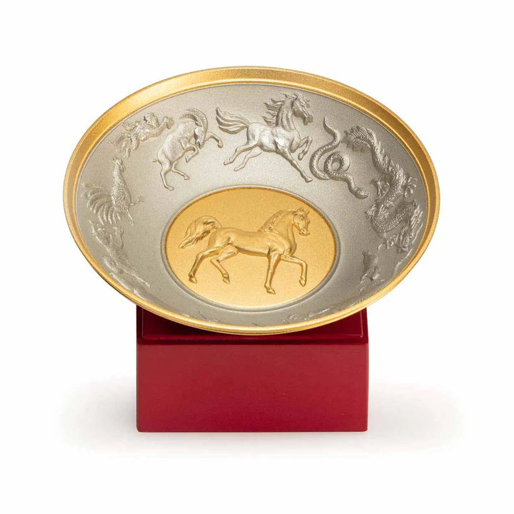 Royal Selangor 2026 Year of the Horse Wealth Bowl featuring a 24K gilt galloping horse at the center medallion, a zodiac frieze around the rim, and a crimson resin base detailed with waves, rocks, and clouds.
