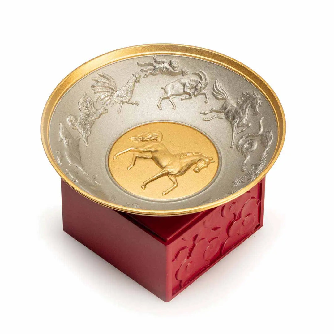 Royal Selangor 2026 Year of the Horse Wealth Bowl featuring a 24K gilt galloping horse at the center medallion, a zodiac frieze around the rim, and a crimson resin base detailed with waves, rocks, and clouds.