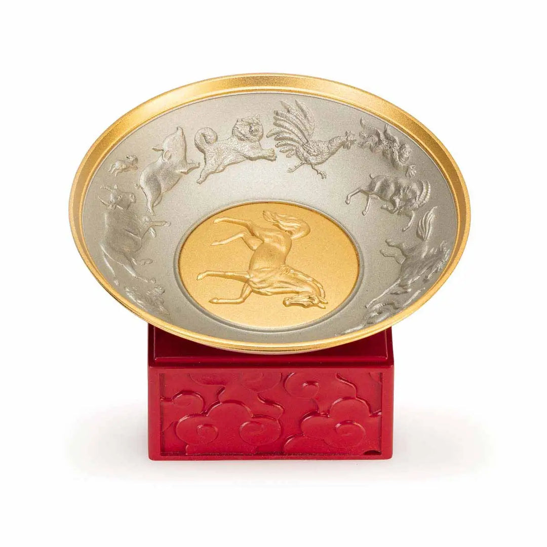 Royal Selangor 2026 Year of the Horse Wealth Bowl featuring a 24K gilt galloping horse at the center medallion, a zodiac frieze around the rim, and a crimson resin base detailed with waves, rocks, and clouds.