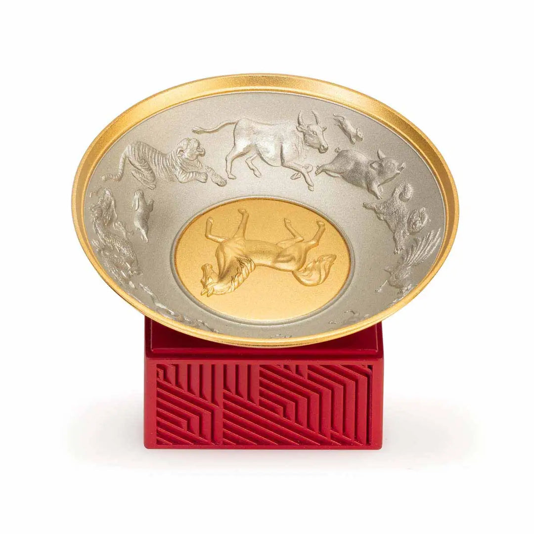 Royal Selangor 2026 Year of the Horse Wealth Bowl featuring a 24K gilt galloping horse at the center medallion, a zodiac frieze around the rim, and a crimson resin base detailed with waves, rocks, and clouds.