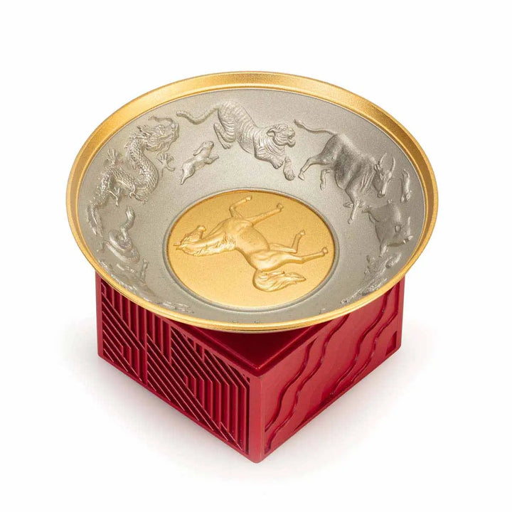 Royal Selangor 2026 Year of the Horse Wealth Bowl featuring a 24K gilt galloping horse at the center medallion, a zodiac frieze around the rim, and a crimson resin base detailed with waves, rocks, and clouds.