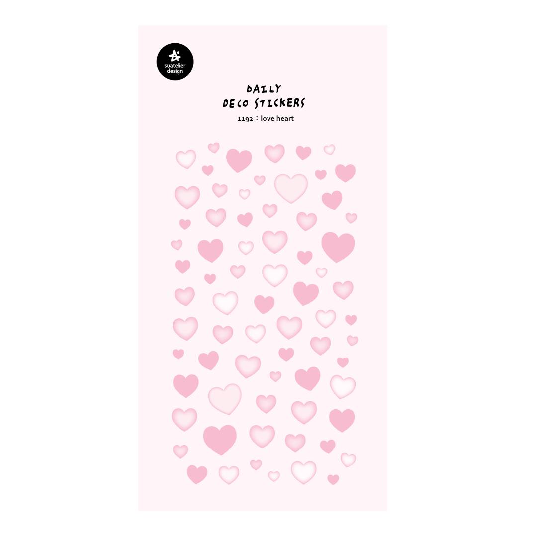 A single sheet of Suatelier Daily Deco Sticker – Love Heart, featuring rows of hand-drawn heart illustrations in different shapes, colors, and sizes on translucent paper.
