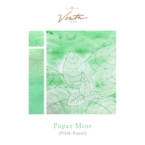 Amber glass bottle of Vinta Inks 30ml in the shade “Paper Mint [Pitik-Papel],” a light mint green ink. The bottle features a charming, nostalgic label and sits next to a swatch of the fresh, playful green ink on white paper.